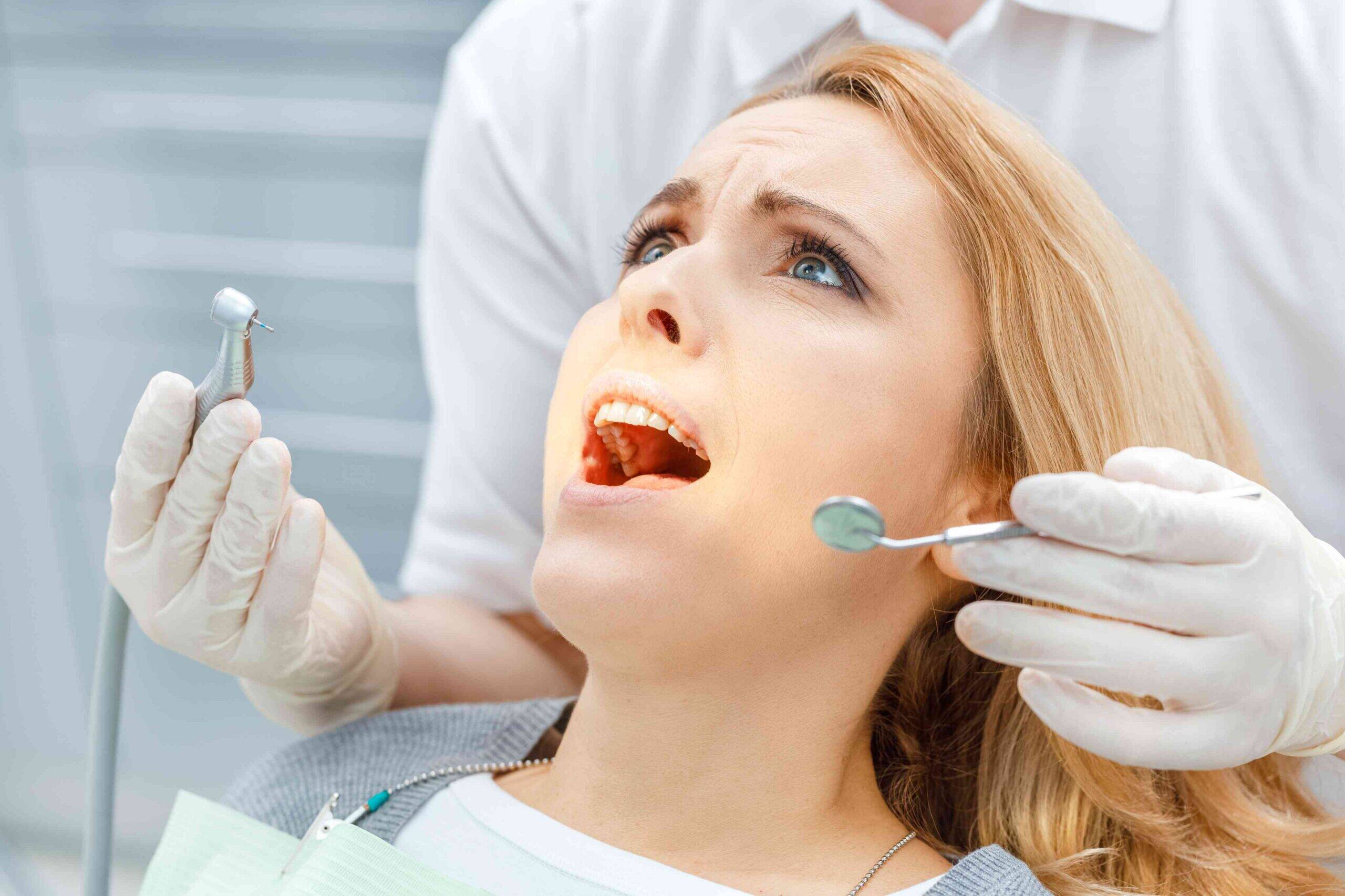 Patient receiving a dental examination with dental instruments.
