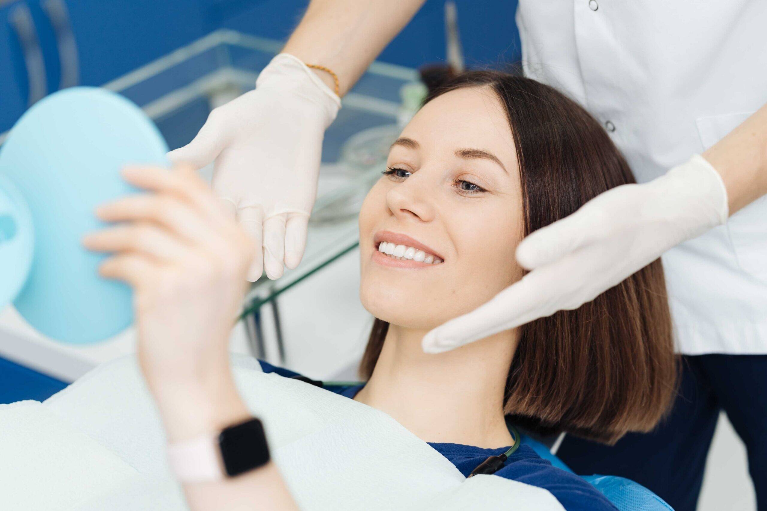 Smiling patient looking in a mirror after dental treatment.