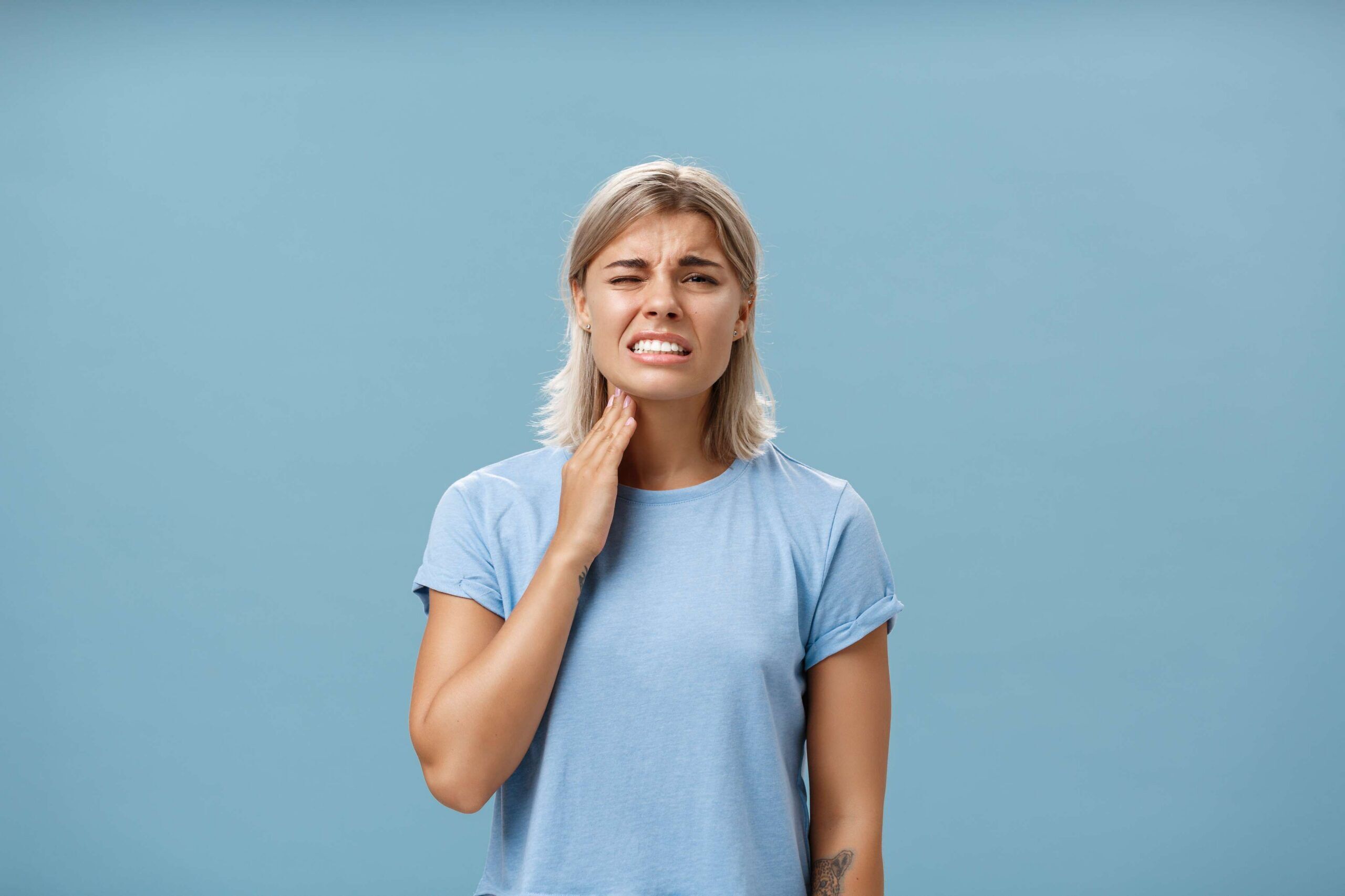 Woman holding her jaw with tooth pain.